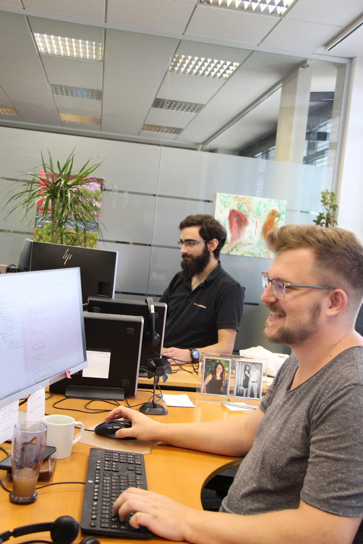 Kollegen an ihren Arbeitspl&auml;tzen im SiteFusion-B&uuml;ro